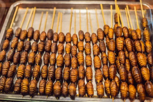 Grill und gebratene Seidenraupenpuppen am Stock aus der Wangfujing Street in Peking, China — Stockfoto