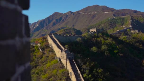 Una sección de la Gran Muralla China que se eleva por el lado de la montaña en un comienzo de otoño — Vídeos de Stock