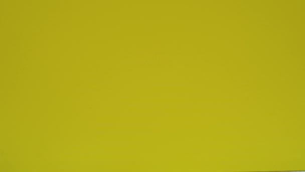 Mango amarillo aparece sobre un fondo amarillo — Vídeo de stock