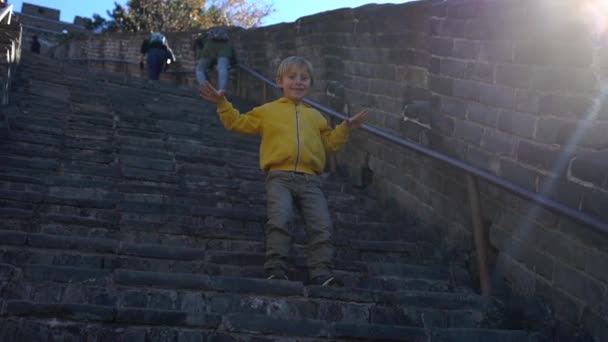 Zeitlupenaufnahme eines glücklichen kleinen Jungen, der Spaß auf der Treppe der chinesischen Mauer hat — Stockvideo