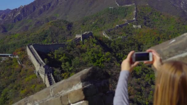 Beijing, Kina - 29 oktober 2018: Slowmotion skott av en kvinna som tar en bild på hennes mobiltelefon av den Kina muren som stiger upp för berget i en början av nedgången — Stockvideo
