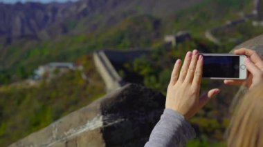 Beijing, Çin - 29 Ekim 2018: Slowmotion atış cep telefonunu dağın diğer tarafa sonbahar başında yükselir Çin büyük duvarın üzerinde bir fotoğraf çeker bir kadının