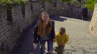 Steadicam atış genç bir kadın ve küçük oğlunu Çin Seddi merdivenlerden yukarı yürümek