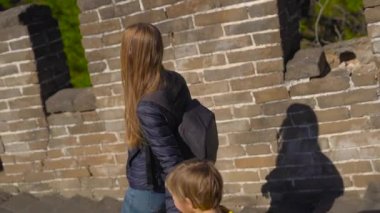 Steadicam atış genç bir kadın ve küçük oğlunu Çin Seddi merdivenlerden aşağı yürüyüş