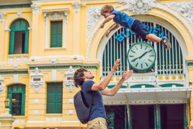 Baba ve oğul arka planda Saigon Merkez Postane mavi gökyüzü arka planda Ho Chi Minh, Vietnam üzerinde. Vietnamca Postane üzerinde yazıt 