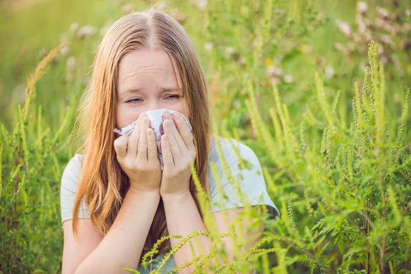 Jeune femme éternue à cause d'une allergie à l'herbe à poux — Photo