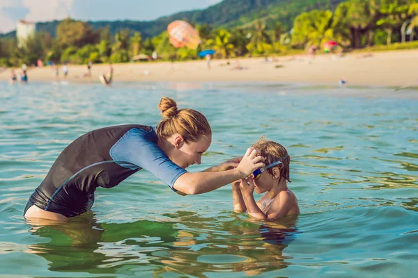 Instruktor plavání žena pro děti učí šťastný chlapec plavat v moři — Stock fotografie