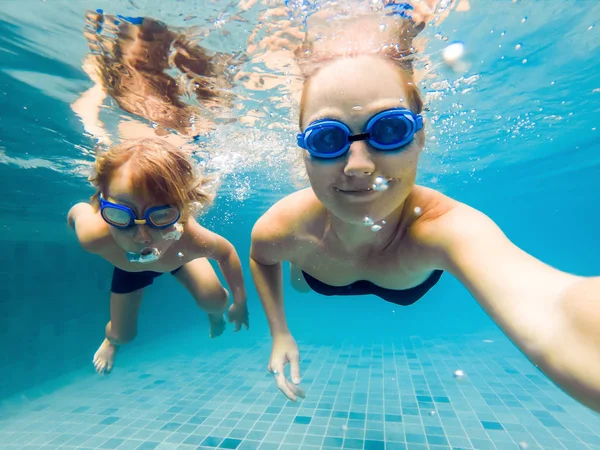 엄마와 아들 다이빙 안경에 물에서 수영장에서 수영 — 스톡 사진