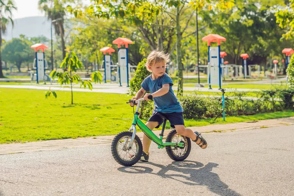 Little boy on a bicycle. Caught in motion, on a driveway. Preschool childs first day on the bike. The joy of movement. Little athlete learns to keep balance while riding a bicycle