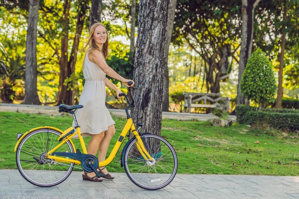 Jonge mooie vrouw een fiets in een park. Actieve mensen. Buiten — Stockfoto