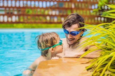 Baba ve oğlu içinde gözlük yüzme havuzunda eğlenin