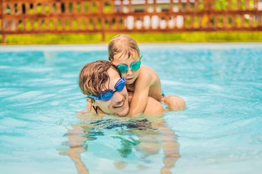 Baba ve oğlu içinde gözlük yüzme havuzunda eğlenin
