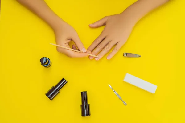 Vrouw handen zorg. Top uitzicht van mooie vlotte dames handen met Professional Nail Care Tools voor Manicure op gele achtergrond. Close-up van gezonde vrouwelijke Nails met gele nagellak. Hoge — Stockfoto