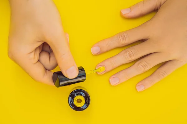 Woman Hands Care. Top View Of Beautiful Smooth Womans Hands With Professional Nail Care Tools For Manicure On yellow Background. Closeup Of Healthy Female Nails With yellow Nail Polish. High — Stock Photo, Image
