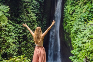 Genç kadın turist Leke Leke şelale Bali Adası Endonezya'da arka plan üzerinde