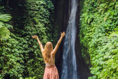 Genç kadın turist Leke Leke şelale Bali Adası Endonezya'da arka plan üzerinde