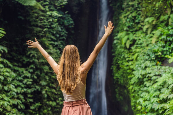 Молодая туристка на фоне водопада Леке-Леке на острове Бали Индонезия
