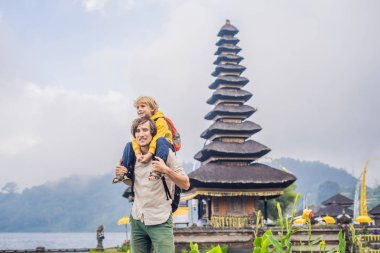 Baba ve oğul Pura Ulun Danu Bratan, Bali arka planda. Hindu Tapınağı çiçek Bratan Gölü, Bali çevrili. Shivaite su Tapınağı Bali, Endonezya Binbaşı. Hindu Tapınağı. Birlikte yolculuk