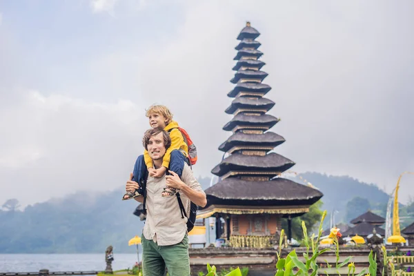 Baba ve oğul Pura Ulun Danu Bratan, Bali arka planda. Hindu Tapınağı çiçek Bratan Gölü, Bali çevrili. Shivaite su Tapınağı Bali, Endonezya Binbaşı. Hindu Tapınağı. Birlikte yolculuk
