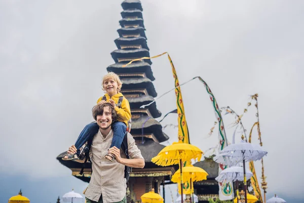 Papá e hijo en el fondo de Pura Ulun Danu Bratan, Bali. Templo hindú rodeado de flores en el lago Bratan, Bali. Mayor templo de agua Shivaite en Bali, Indonesia. Templo hindú. Viajar con — Foto de Stock