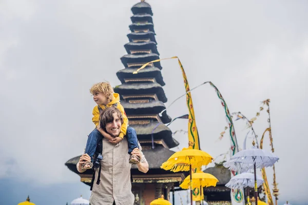 Papá e hijo en el fondo de Pura Ulun Danu Bratan, Bali. Templo hindú rodeado de flores en el lago Bratan, Bali. Mayor templo de agua Shivaite en Bali, Indonesia. Templo hindú. Viajar con —  Fotos de Stock