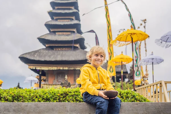 Pura Ulun Danu Bratan, 발리의 배경에서 소년 여행자. 힌두교 사원 Bratan 호수, 발리에 꽃으로 둘러싸인. 발리, 인도네시아의 주요 Shivaite 물 사원입니다. 힌두교 사원입니다. 함께 여행 — 스톡 사진