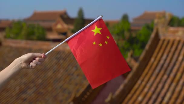 Женщина с маленьким флагом Китая в руках. Концепция путешествия в Китай — стоковое видео
