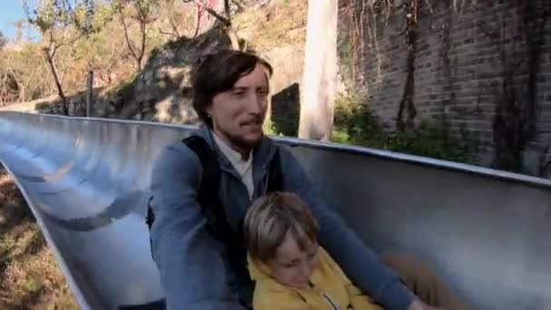 父と息子の秋の森アルペン コースターを乗ってのスローモーション撮影 — ストック動画
