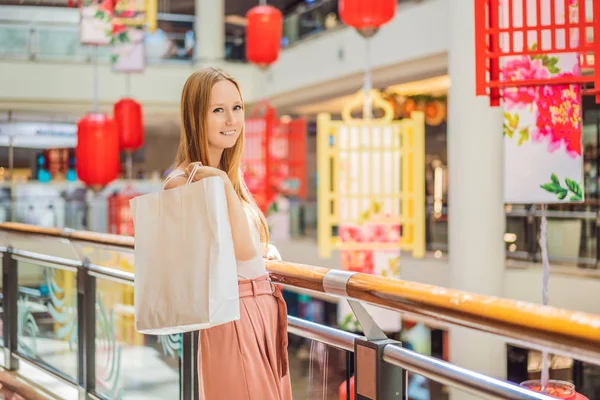 Mulher segurar saco de compras contra o fundo de lanternas vermelhas chinesas para o Ano Novo Chinês. Grande venda em honra da véspera de Ano Novo. Preto chinês sexta-feira 11.11 — Fotografia de Stock