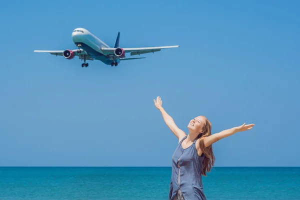 Mujer joven en la playa y aviones de aterrizaje. Concepto de viaje —  Fotos de Stock