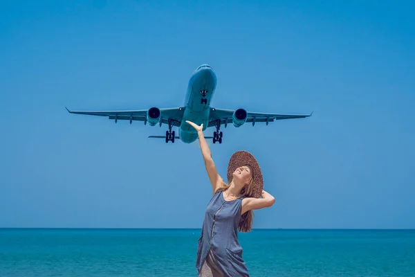 Νεαρή γυναίκα σχετικά με τα αεροπλάνα της παραλίας και την προσγείωση. Έννοια του ταξιδιού — Φωτογραφία Αρχείου