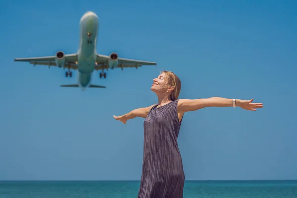 Mujer joven en la playa y aviones de aterrizaje. Concepto de viaje — Foto de Stock