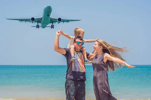 Famiglia felice sulla spiaggia e aereo atterraggio. Viaggiare con i bambini concetto — Foto Stock