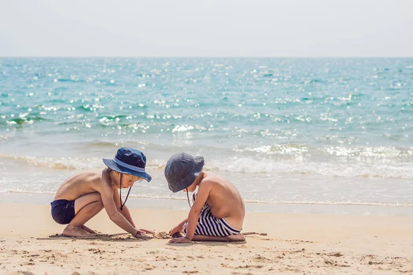 Due giovani ragazzi si divertono sulla spiaggia tropicale, felici migliori amici che giocano — Foto Stock