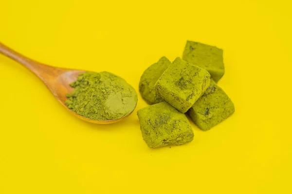 Bubuk korek api dan permen yang terbuat dari matcha dengan latar belakang kuning. Matcha Buatan sendiri — Stok Foto