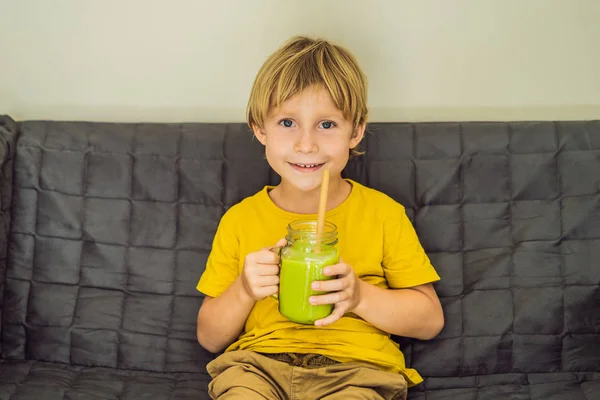 El chico está bebiendo té verde con leche y hielo en un frasco de albañil. Té helado hecho en casa Matcha Latte con leche cero residuos — Foto de Stock