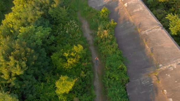 Scatto aereo di una giovane donna che corre sul territorio di una vecchia fortezza della prima guerra mondiale durante il tramonto, l'alba. Vista dall'alto — Video Stock