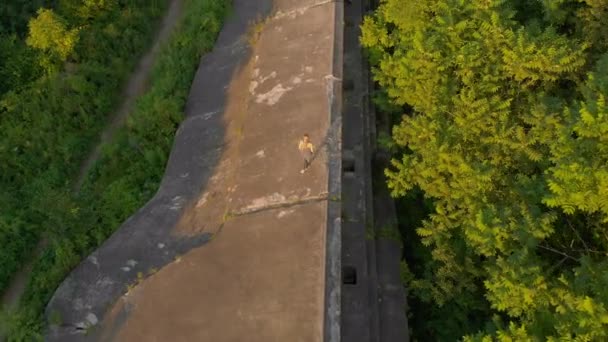 日落、日出时, 一名年轻女子在一座古老的一座世界战争要塞上奔跑的空中镜头 — 图库视频影像