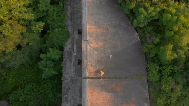 Foto aérea de una joven mujer corriendo sobre una antigua fortaleza de la Primera Guerra Mundial al atardecer, al amanecer — Vídeo de stock