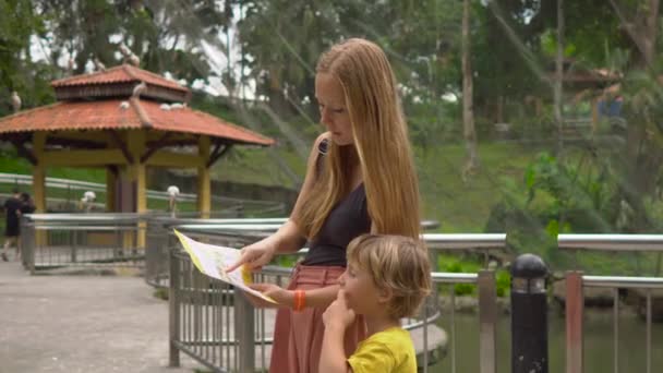 KUALA LUMPUR, MALAYSIA - NOVEMBER 22, 2018: Young woman and her little son visit a bird park in tropics — Stock Video