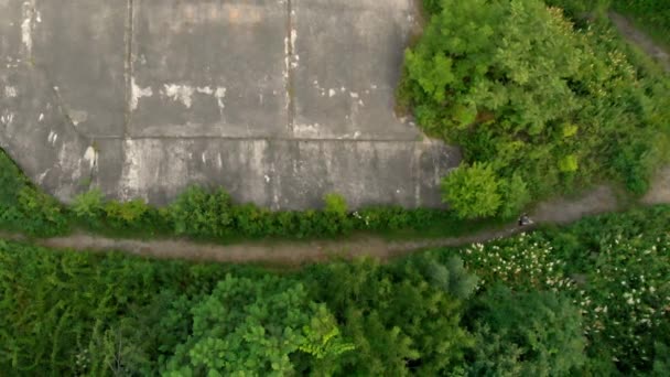 Foto aérea de un joven corriendo en el territorio de una antigua fortaleza de la Primera Guerra Mundial al atardecer, al amanecer — Vídeo de stock