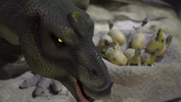 Beijing, Kina - 22 oktober 2018: modell av dinosaurie vaktar utläggning av ägg med kläckning små dinosaurier — Stockvideo