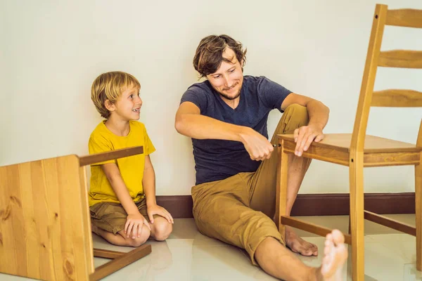 Pai e filho montando móveis. Rapaz a ajudar o pai em casa. Conceito de família feliz — Fotografia de Stock