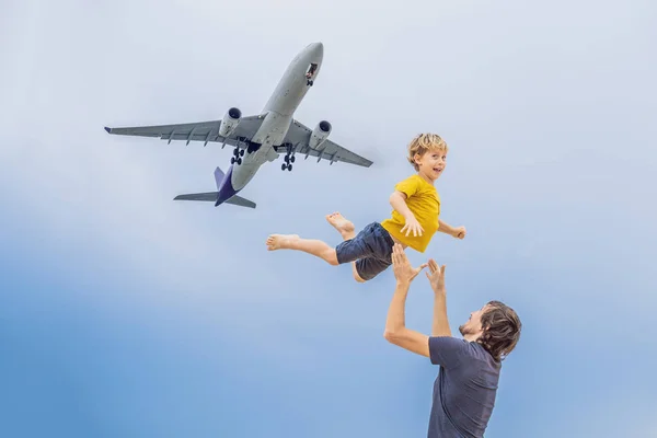 Padre e hijo se divierten en la playa viendo los aviones de aterrizaje. Viajar en un avión con concepto de niños —  Fotos de Stock