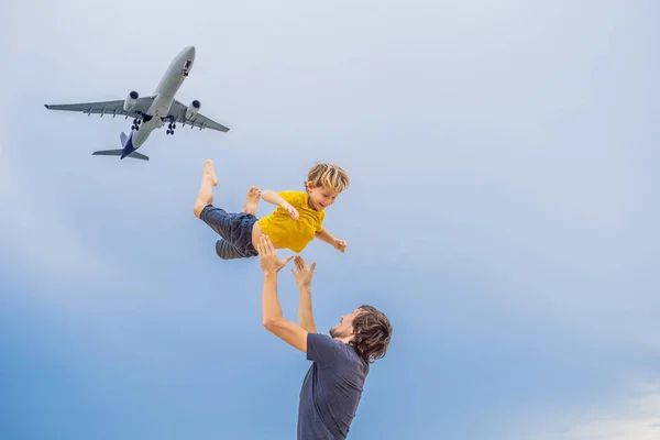 父と息子は、着陸飛行機を見てビーチで楽しい時を過します。子供たちのコンセプトと飛行機の旅 — ストック写真