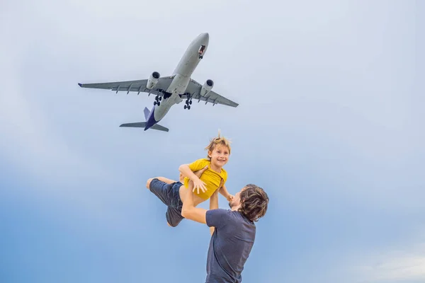 父と息子は、着陸飛行機を見てビーチで楽しい時を過します。子供たちのコンセプトと飛行機の旅 — ストック写真