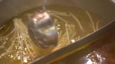 Genç kadın bir Asya kafe aşçı gıda bir güveç içinde. Yiyecek bir konveyör küçük tabaklarda servis edilir. Gıda konveyör.