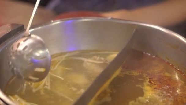 Молодая женщина в азиатском кафе готовит еду в горячем котле. Еда подается на конвейере на маленьких тарелочках. Продовольственный конвейер . — стоковое видео