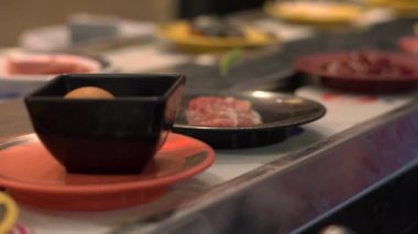 Gıda konveyör. Küçük bir tabak içinde bir konveyör taşıma gıda ile Asya tarzı kafe. Gıda israf kavramı. overeating israf kavramı