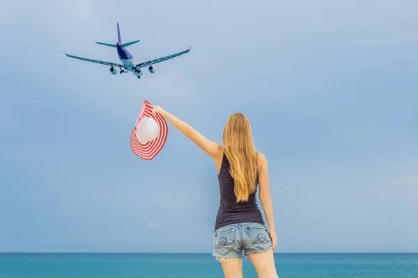 Γυναίκα διασκεδάστε στην παραλία βλέποντας τα προσγειωμένος αεροπλάνα. Ταξιδεύετε σε μια έννοια αεροπλάνο — Φωτογραφία Αρχείου